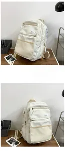 Detail view of the multi-pocket off-white student backpack with side buckles and mesh pockets