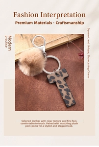Close-up of leopard print leather letter T keychain with fluffy brown faux fur pompom ball