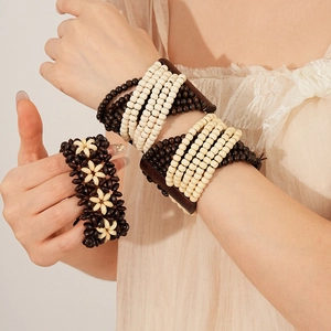 Detail of layered coconut wood bead bracelet featuring dark brown and cream floral patterns
