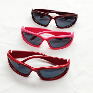 Y2K punk style athletic sunglasses in red and pink displayed on a white fabric background