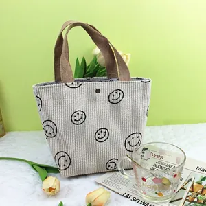 Détail du sac cabas en velours côtelé crème avec imprimés smiley et anses en tissu brun