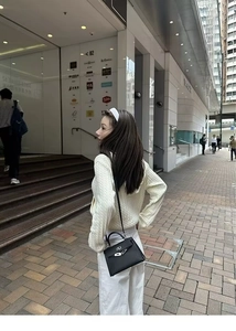 Close-up of a women off-white cable knit zip-up hoodie featuring a cozy hood and textured pattern
