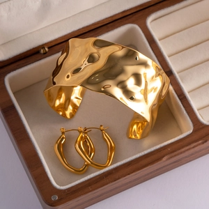 Detail of 18K gold hammered texture bracelet and earrings set in wooden jewelry box