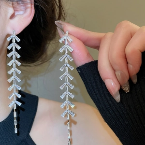 Détail de boucles d'oreilles pendantes en argent avec zircons en forme de V élégant