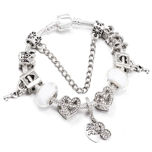 Silver DIY charm bracelet with heart pendants, white glass beads, and crown on snake chain