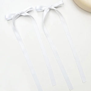 Detail of white satin ribbon bow hair clips with long elegant dangling streamers