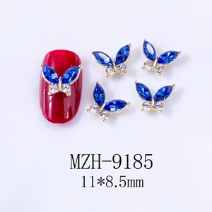 Detail of 3D blue butterfly nail charms with marquise crystals on red nail tips