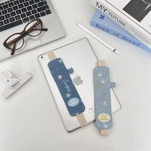 Detail of denim stylus holders with elastic straps, starry patterns and embroidery accents