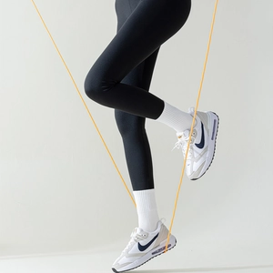 Dynamic view of anti-slip yoga socks and sneakers worn by a model jumping rope