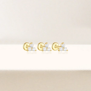 Close-up of golden S925 sterling silver stud earring featuring three white zircons