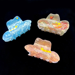 Three acrylic cowboy hat hair claws in blue, yellow, and pink with star patterns