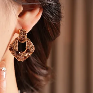 Boucles d'oreilles vintage en or avec zircons ambrés portées par un mannequin