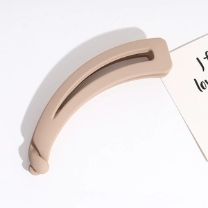 Detailed view of large matte beige banana hair clip showing its sleek hollow design