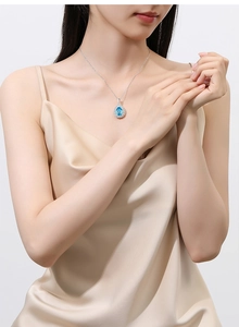 Close-up of elegant blue water-drop pendant necklace with silver chain on model