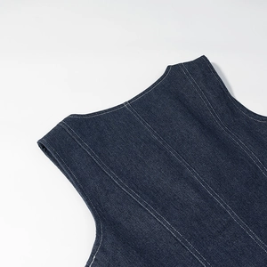 Gros plan du tissu denim bleu foncé avec des surpiqûres blanches et une texture en sergé