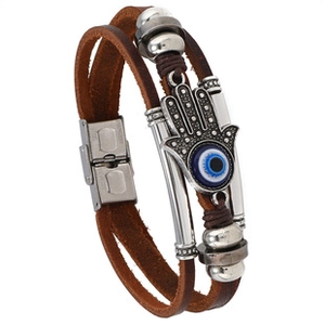 Macro detail of brown leather multi-layer bracelet with silver Hamsa Hand and Blue Evil Eye charm