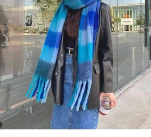 Detail of soft blue plaid scarf with fringe texture worn in a modern street style look