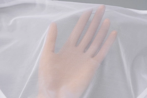 Vue macro détaillée du tissu en maille blanche montrant la texture fine et transparente