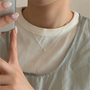 Minimalist 925 silver knotted heart necklace on model in mirror selfie view