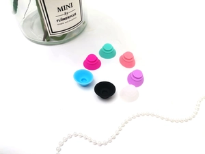 Flat lay of colorful silicone facial ice roller suction pads on a white background