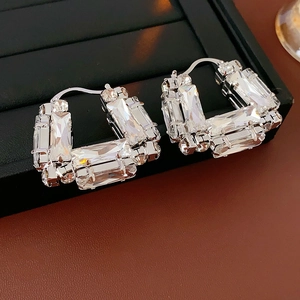 Gros plan sur les boucles d'oreilles argentées en U avec détails en zircon rectangulaire