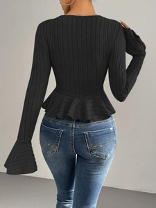 Detail of elegant black long sleeve peplum top with ruffle hem and ribbed texture