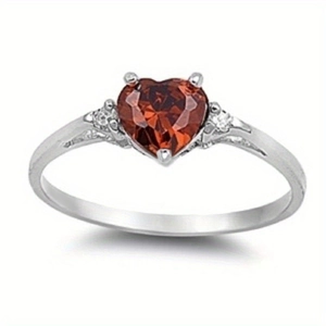 Detail shot of heart-cut red gemstone ring in silver setting with side stones