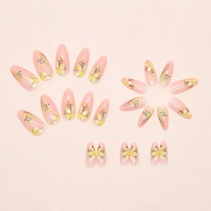 Detailed view of long oval press on nails with hand-painted yellow floral patterns
