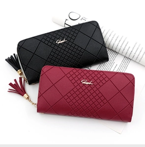 Detail of diamond quilted texture and tassel zippers on black and burgundy long wallets