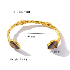 Detailed view of adjustable gold-plated bangle featuring oval brown stones and 68mm diameter