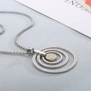 Detailed view of silver and gold circular pendant with micro-pave crystals on chain