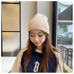 Detail of soft ribbed knit beanie featuring an embroidered mountain logo on female model