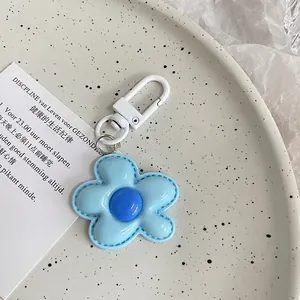 Detail of light blue faux leather flower charm with fine stitching and white spring clasp
