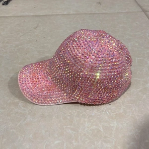 Detail shot of a pink sparkling rhinestone baseball cap with iridescent AB crystal gems