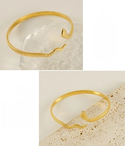 Detail of 18k gold snake-shaped bangle with realistic scale texture and smooth metallic finish