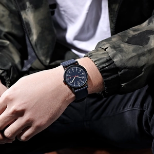 Close-up of a military-style men's watch with blue nylon strap and dual-time dial display
