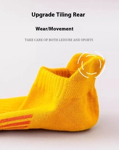 Detail of yellow athletic ankle socks featuring reinforced high heel tab and orange stripes