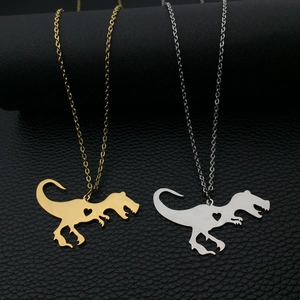 Dettaglio macro dei ciondoli a dinosauro con cuore in finitura oro e argento