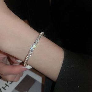Close-up of classic silver tennis bracelet with sparkling zircons on a woman wrist