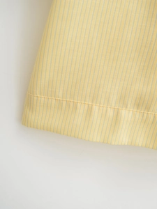 Detailed macro view of yellow and blue striped cotton-linen fabric with clean hem stitching