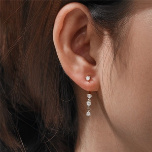 Macro detail of 925 sterling silver C-shaped earrings with sparkling zircon stones