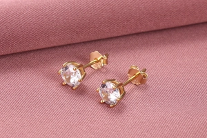 Macro shot of gold-plated 925 silver six-prong stud earrings with white round-cut zircon