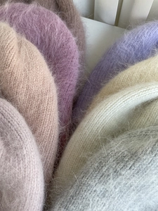 Nahaufnahme weicher Angora-Strickmützen mit flauschiger Textur und Pastellfarben
