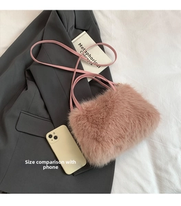 Close-up of soft pink faux fox fur shoulder bag with slender straps and plush texture
