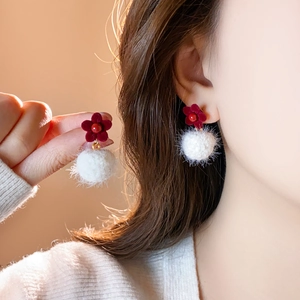 Detailed shot of flocking flower studs with white plush pompom and gold link accents