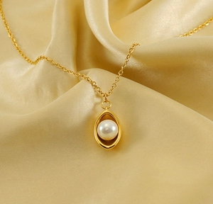 Detail of 18k gold plated stainless steel necklace with oval pendant and pearl