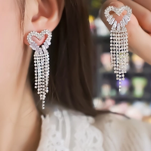 Silver heart tassel drop earrings with sparkling cubic zirconia on female model