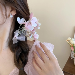 Detailed view of pink floral hair claw clip with bow on a braided hairstyle