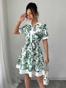 Close-up of green floral print detail on a white short-sleeve button-down shirt dress
