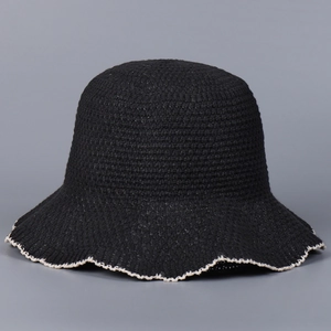 Detailed macro view of black knit sun hat with decorative white scalloped wave edge